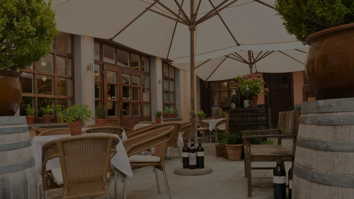 Hofterrasse des Hotel Laurentius mit eingedeckten Tischen und Weinfässern