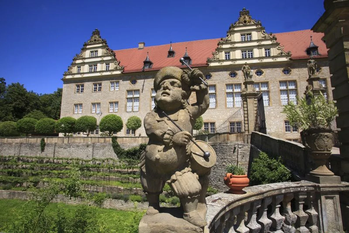 Renaissance-Schloss Weikersheim mit Zwergenfigur im Schlossgarten